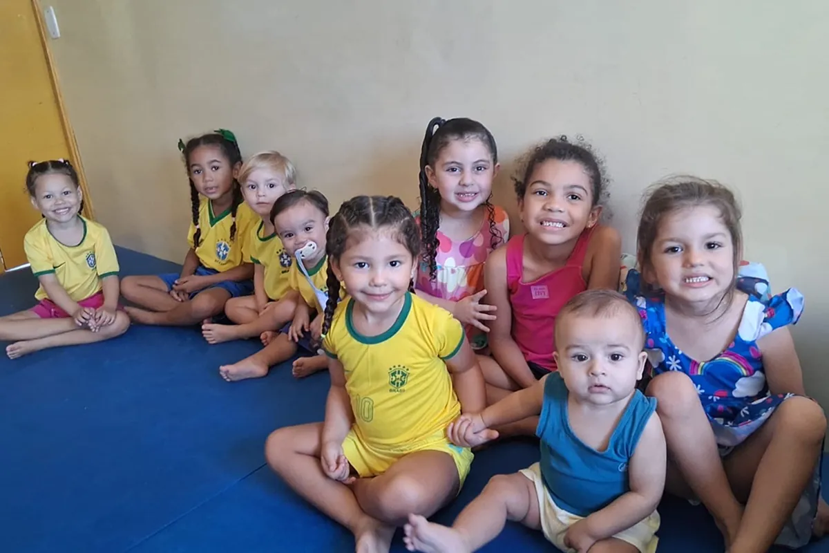 Grupo de crianças vestidas com as cores do Brasil em clima de Copa